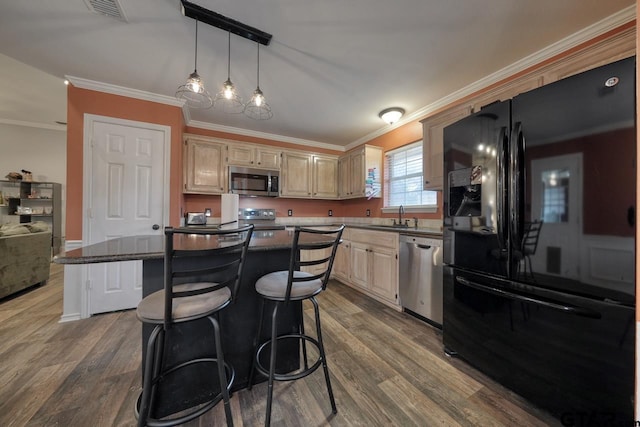 kitchen with a center island, stainless steel appliances, visible vents, a sink, and wood finished floors