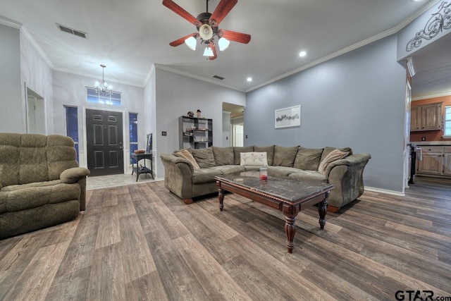 living room featuring ceiling fan with notable chandelier, wood finished floors, visible vents, and crown molding