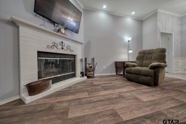 sitting room featuring ornamental molding, a fireplace, baseboards, and wood finished floors