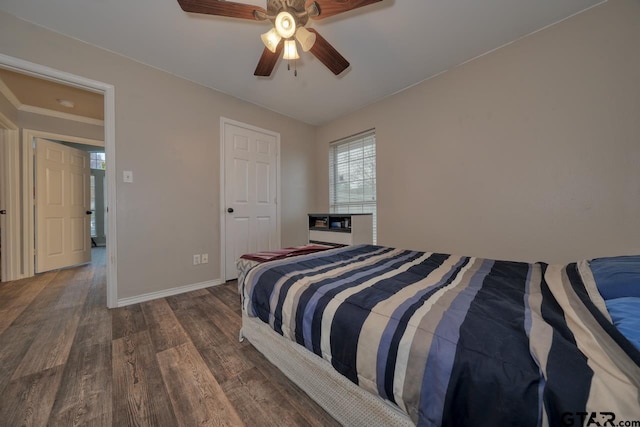 bedroom featuring ceiling fan, baseboards, and dark wood-type flooring