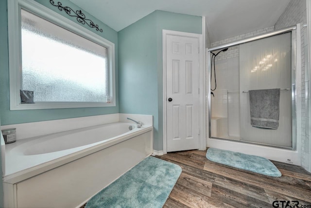 bathroom featuring wood finished floors, a stall shower, and a garden tub