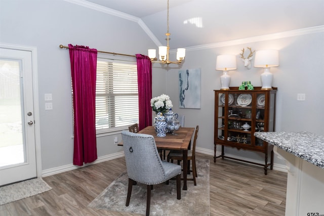 dining room with light wood-type flooring, crown molding, and vaulted ceiling