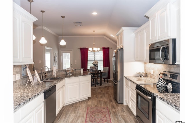 kitchen with stainless steel appliances, hanging light fixtures, and white cabinetry