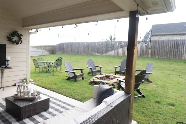 view of yard with an outdoor living space with a fire pit and a patio area