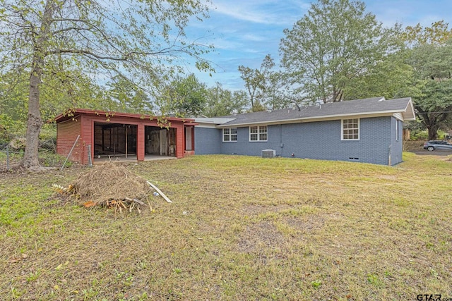 rear view of property with central air condition unit and a lawn