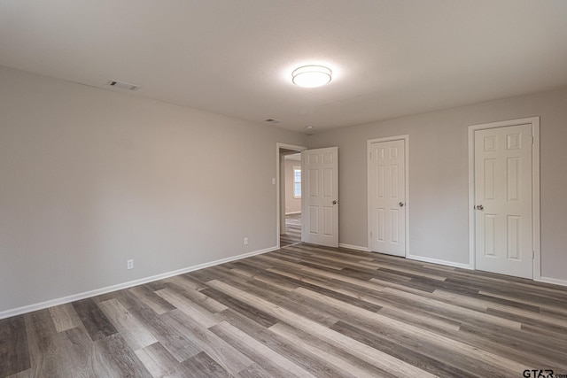 unfurnished bedroom featuring dark hardwood / wood-style flooring and a textured ceiling