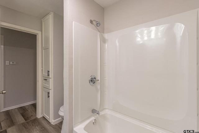 bathroom featuring shower / bathing tub combination, wood-type flooring, and toilet