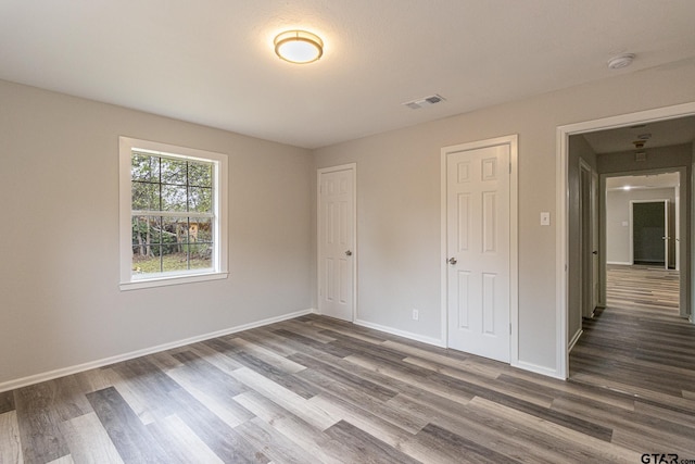 unfurnished bedroom featuring dark hardwood / wood-style flooring