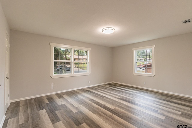 unfurnished room with dark hardwood / wood-style floors and plenty of natural light