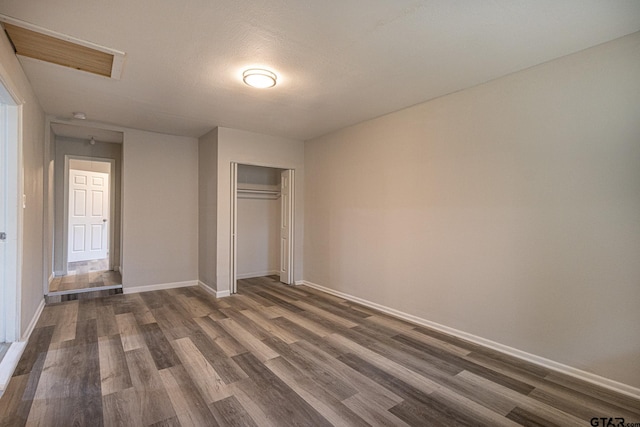 unfurnished bedroom featuring dark hardwood / wood-style flooring, a textured ceiling, and a closet