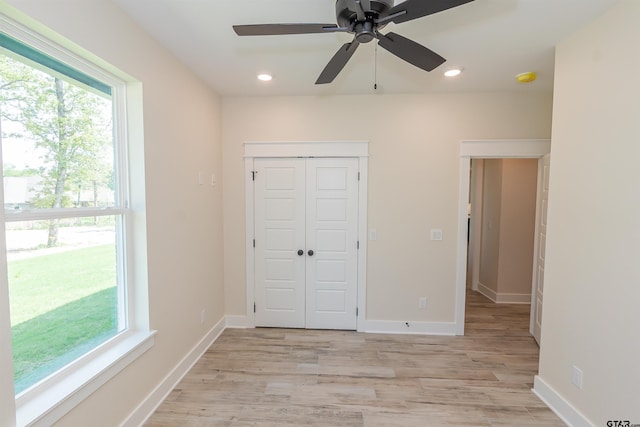 unfurnished bedroom with light wood-type flooring, recessed lighting, and a closet