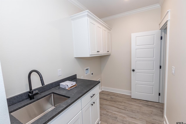 interior space with a sink, hookup for an electric dryer, cabinet space, ornamental molding, and washer hookup