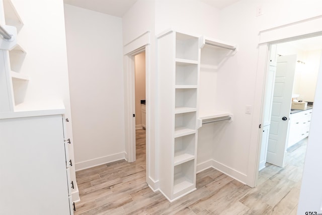 walk in closet with light wood-type flooring
