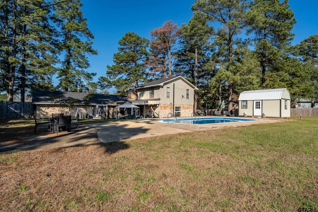 view of yard featuring a storage unit, a fenced in pool, and a patio