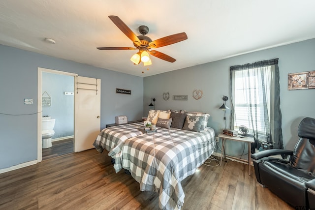 bedroom with ceiling fan, ensuite bathroom, and dark wood-type flooring