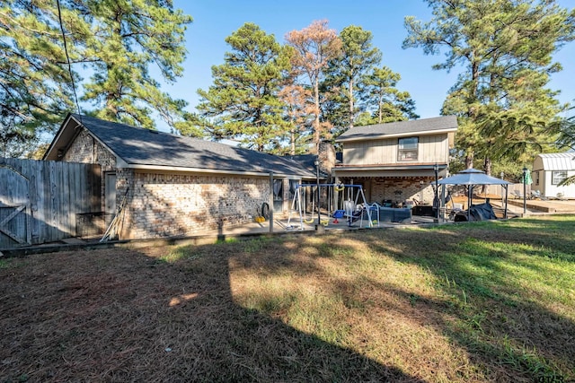 rear view of house featuring a patio area and a yard