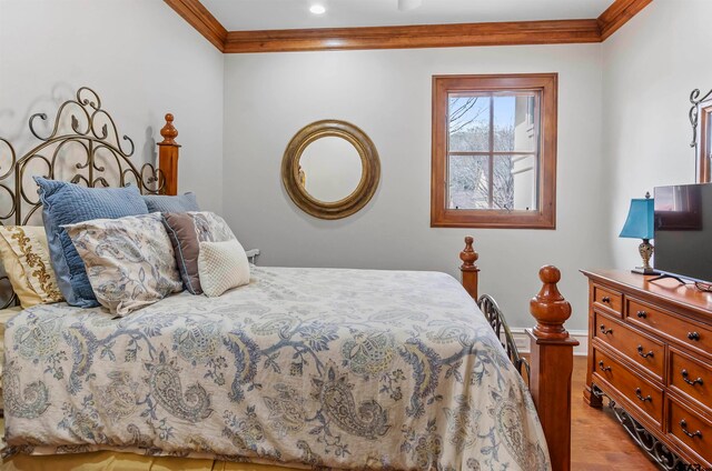 bedroom featuring crown molding and light hardwood / wood-style flooring