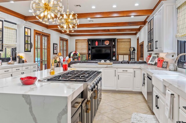 kitchen featuring white cabinets, pendant lighting, light stone counters, and a notable chandelier