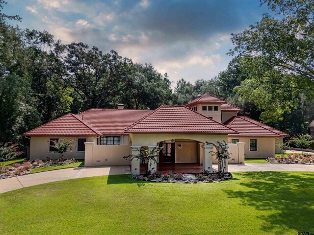 mediterranean / spanish home with a front lawn