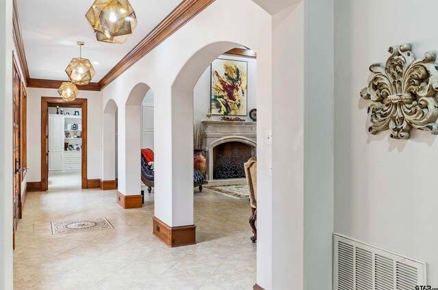 hall with crown molding and light tile patterned floors