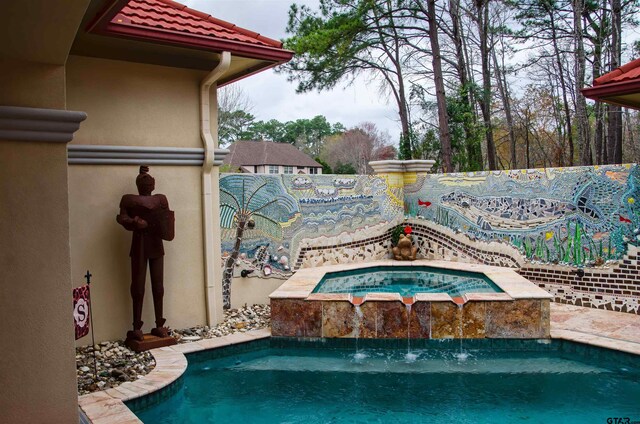 view of pool with an in ground hot tub