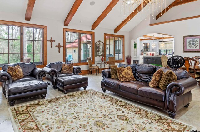 living room with beam ceiling, a wealth of natural light, and high vaulted ceiling