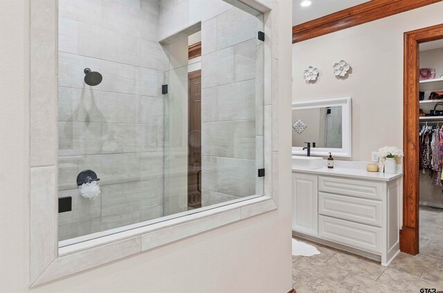 bathroom featuring crown molding, vanity, and tiled shower