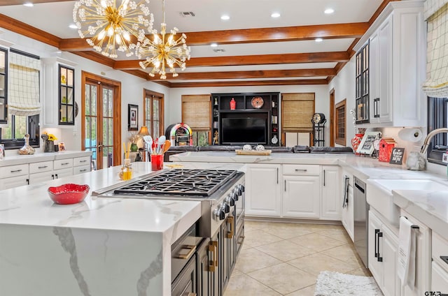 kitchen with light stone countertops, a chandelier, white cabinets, and pendant lighting