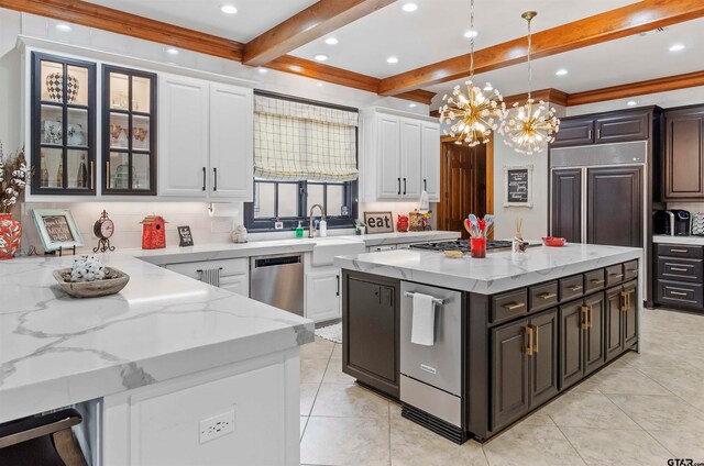 kitchen featuring white cabinets, hanging light fixtures, a kitchen island, dark brown cabinetry, and stainless steel appliances