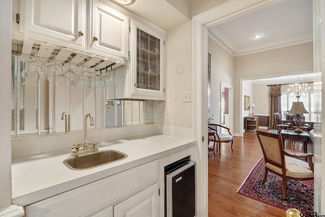 1807 Royal Oak Dr, Tyler, TX 75703 - indoor wet bar featuring light wood finished floors, crown molding, and wine cooler