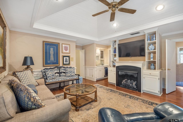1807 Royal Oak Dr, Tyler, TX 75703 - living room featuring wood finished floors, a tray ceiling, ceiling fan, a fireplace, and crown molding