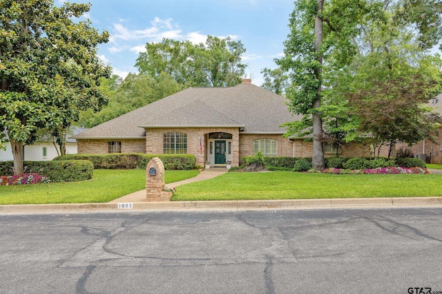 1807 Royal Oak Dr, Tyler, TX 75703 - view of front of home featuring brick siding, a front yard, and roof with shingles