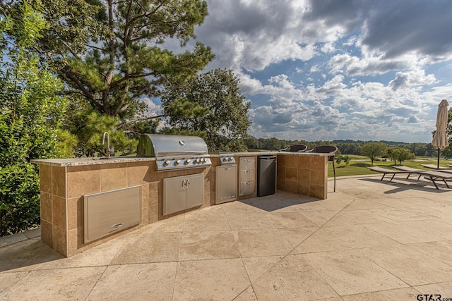 view of patio featuring exterior kitchen, sink, and grilling area