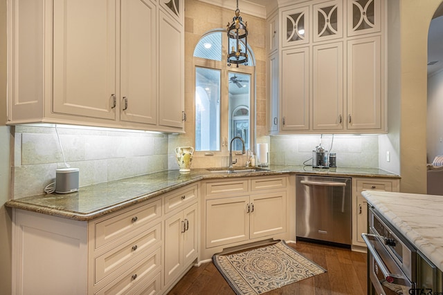 kitchen featuring dark wood-type flooring, light stone counters, dishwasher, sink, and pendant lighting