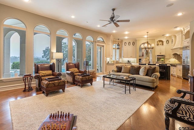 living room featuring hardwood / wood-style flooring and ceiling fan with notable chandelier