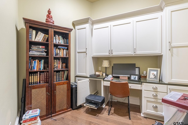 office space with light wood-type flooring and built in desk