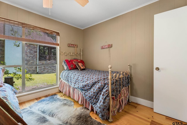 bedroom featuring ceiling fan, ornamental molding, and hardwood / wood-style floors