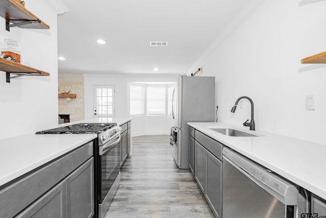 kitchen with stainless steel appliances, crown molding, sink, and gray cabinets