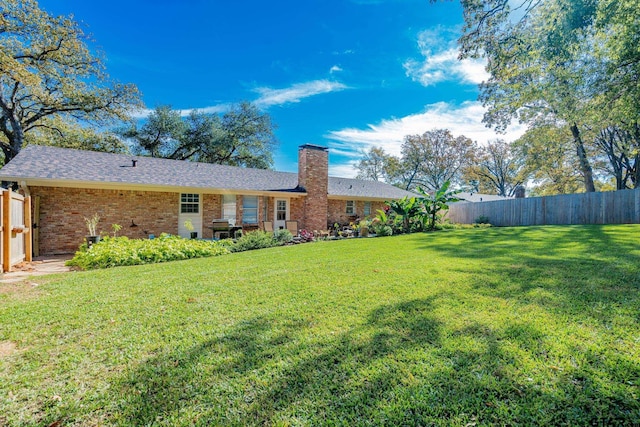 rear view of property with a yard