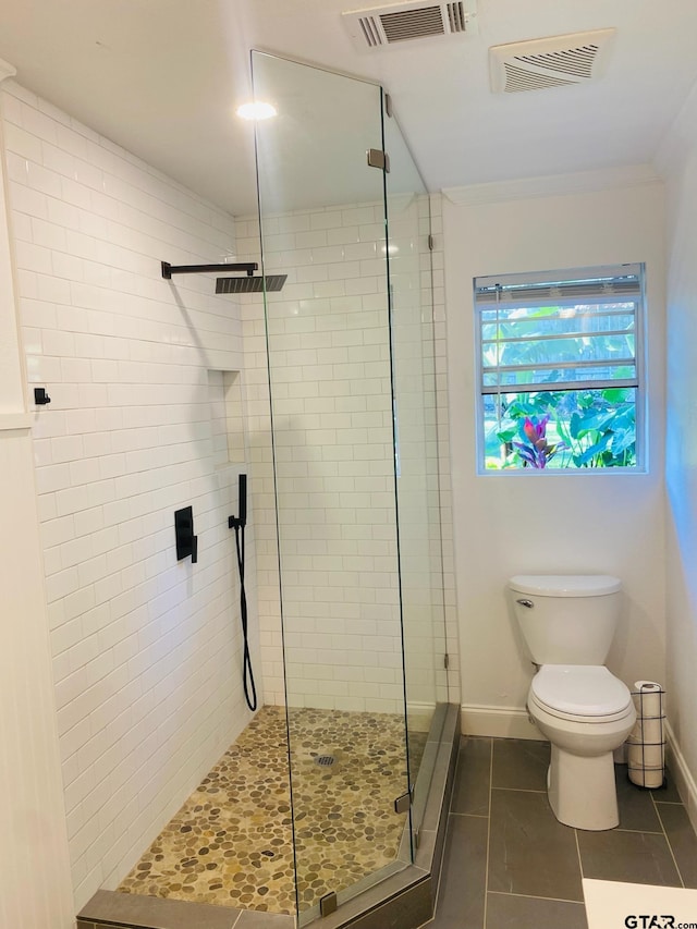 bathroom with ornamental molding, tile patterned floors, toilet, and a shower with door