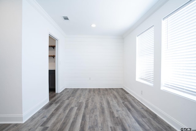 unfurnished room with crown molding and dark wood-type flooring