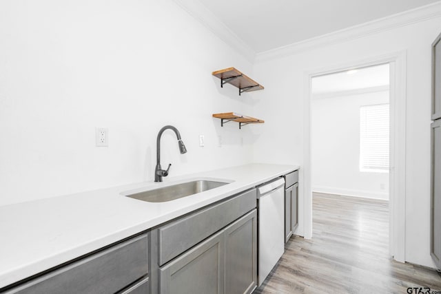 kitchen featuring gray cabinets, sink, stainless steel dishwasher, crown molding, and light hardwood / wood-style flooring