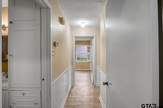 3316 Lynnwood Dr, Tyler, TX 75701 - hallway with wainscoting, wood finished floors, and a decorative wall