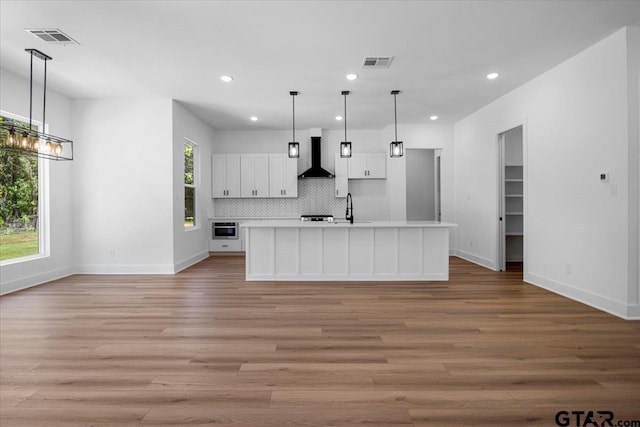17314 Fm 2767, Tyler, TX 75705 - kitchen with wall chimney exhaust hood, recessed lighting, baseboards, a sink, and light countertops
