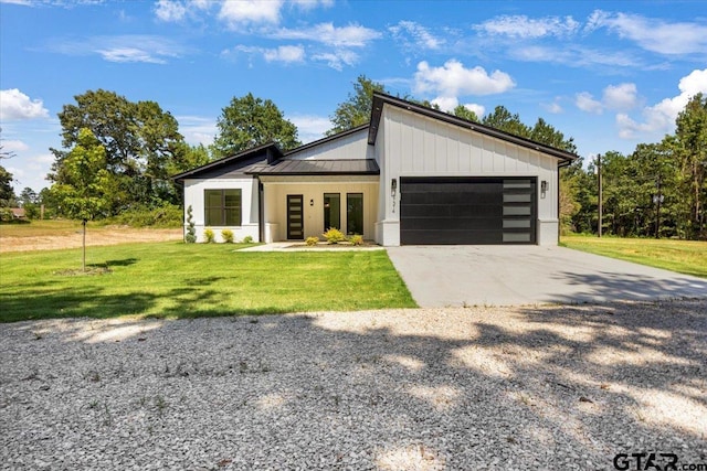 17314 Fm 2767, Tyler, TX 75705 - contemporary house featuring concrete driveway, an attached garage, a front lawn, a standing seam roof, and metal roof