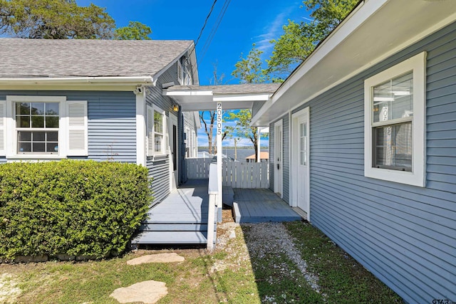 view of property exterior featuring roof with shingles and a deck