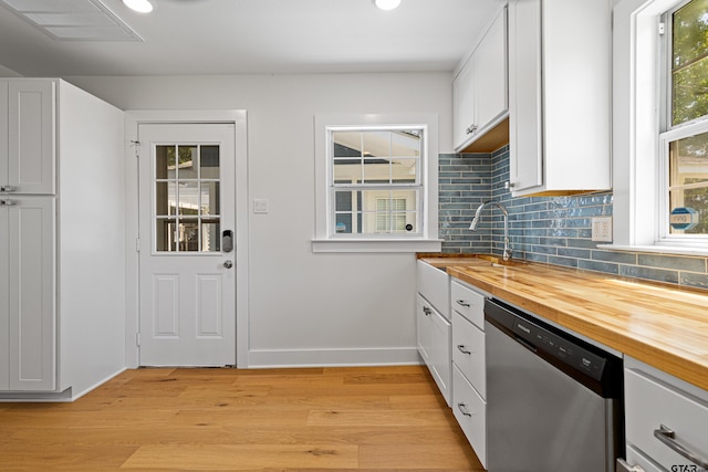 kitchen featuring stainless steel dishwasher, light wood finished floors, and wooden counters