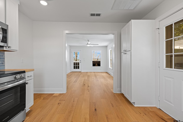 kitchen with visible vents, white cabinetry, and stainless steel electric range