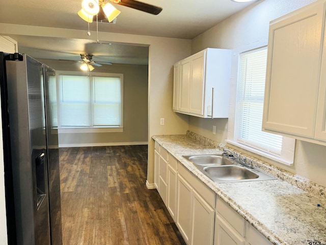 kitchen featuring a sink, light countertops, dark wood-type flooring, and stainless steel fridge