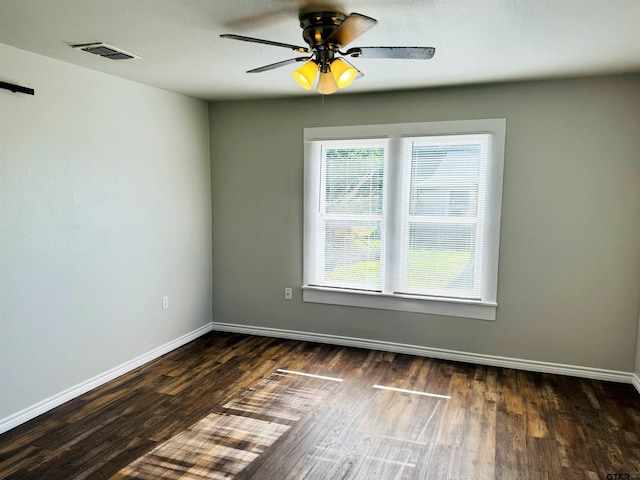 spare room with ceiling fan, wood finished floors, visible vents, and baseboards